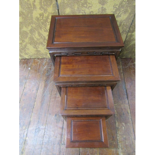 2607 - A graduated set of four Chinese hardwood occasional tables of rectangular form with carved borders, ... 