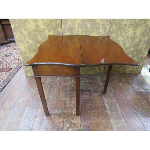 2608 - A Georgian mahogany fold over top tea table, the serpentine top raised on a rectangular base with sq... 