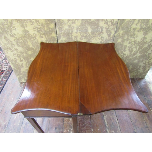 2608 - A Georgian mahogany fold over top tea table, the serpentine top raised on a rectangular base with sq... 