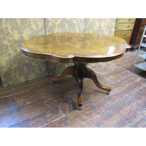 2622 - A Victorian walnut and figured walnut loo table with quarter veneered top, shaped outline and raised... 