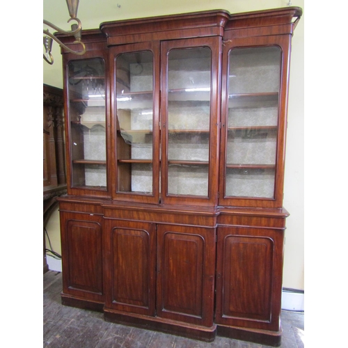 2628 - A Victorian mahogany four door breakfront library bookcase, the lower section enclosed by arched and... 