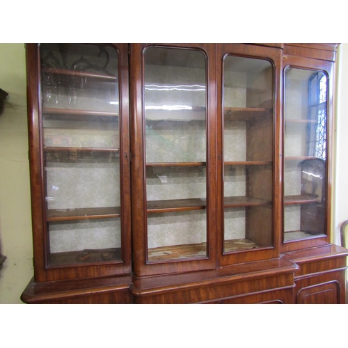 2628 - A Victorian mahogany four door breakfront library bookcase, the lower section enclosed by arched and... 