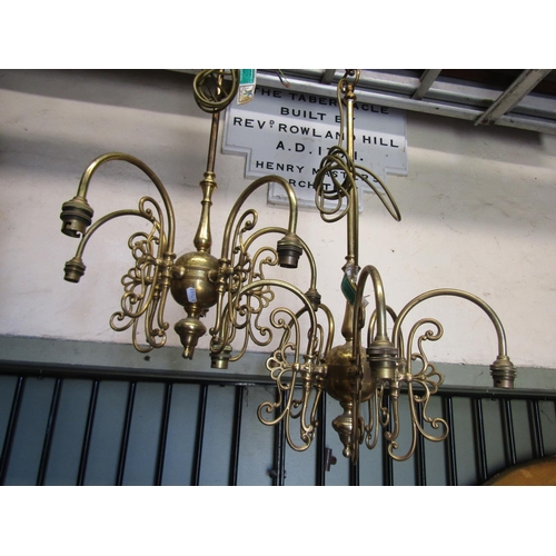 2115 - A pair of cast brass four branch hanging ceiling lights with long stems and scrolling foliate detail... 