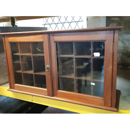 2162 - An Edwardian mahogany and pine cabinet enclosed by a pair of glazed panelled doors with pigeon holed... 