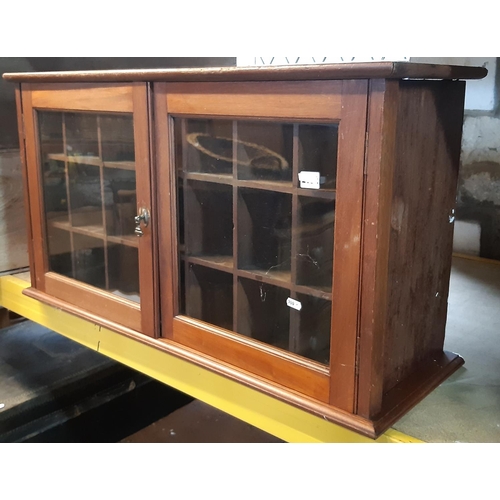 2162 - An Edwardian mahogany and pine cabinet enclosed by a pair of glazed panelled doors with pigeon holed... 