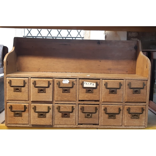 2164 - A vintage stripped oak bank of twelve small index drawers with brass flush fitting handles, 86 cm wi... 