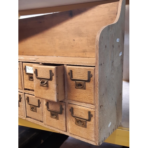 2164 - A vintage stripped oak bank of twelve small index drawers with brass flush fitting handles, 86 cm wi... 