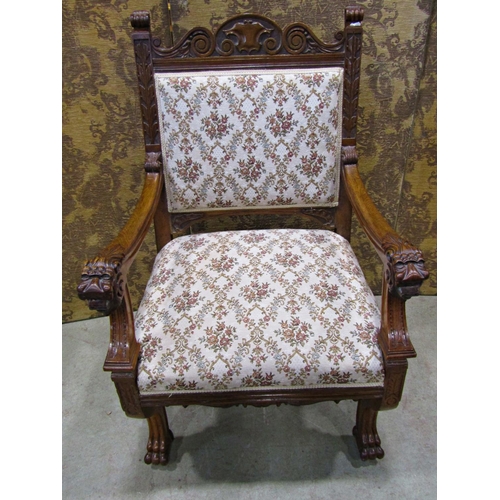 2168 - A Victorian carved oak open armchair with lions mask and foliate detail, upholstered seat and back r... 