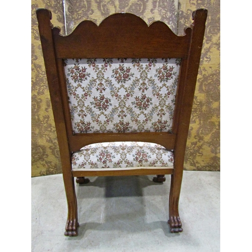 2168 - A Victorian carved oak open armchair with lions mask and foliate detail, upholstered seat and back r... 