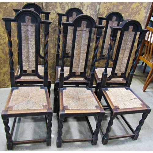 2175 - A set of six oak high back dining chairs with rush seats and back panels raised on spiral twist supp... 