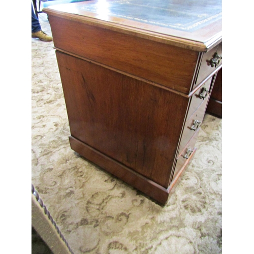 2186 - A late Victorian/Edwardian walnut kneehole twin pedestal writing desk with inset leather top over an... 