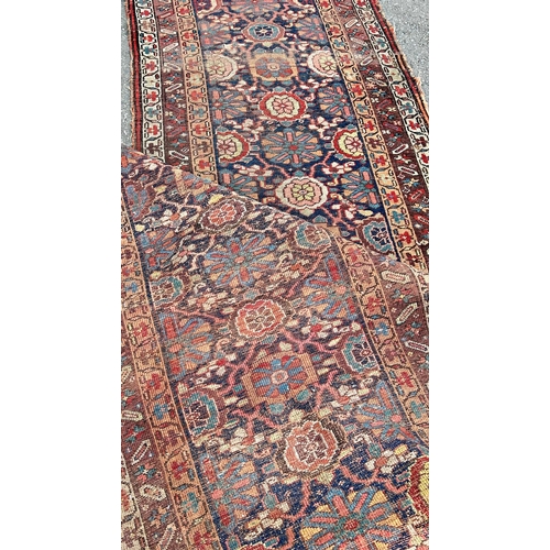 1688 - An old Persian hand knotted runner with an all over stylised floral design, 346 cm x 104 cm approxim... 