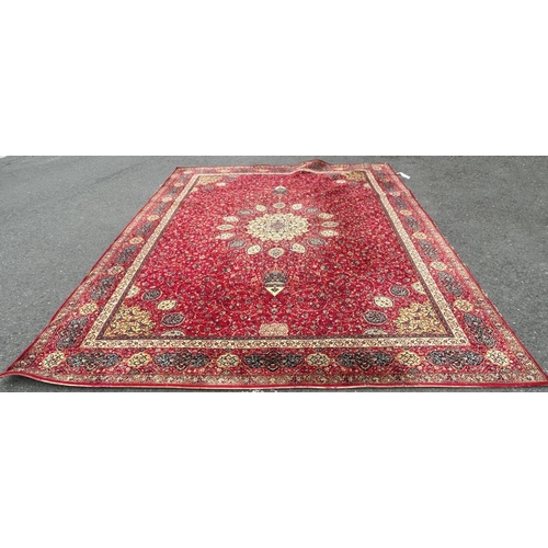 1695 - A large Wilton type carpet with a Persian design of a central medallion on a field of flowers on a r... 