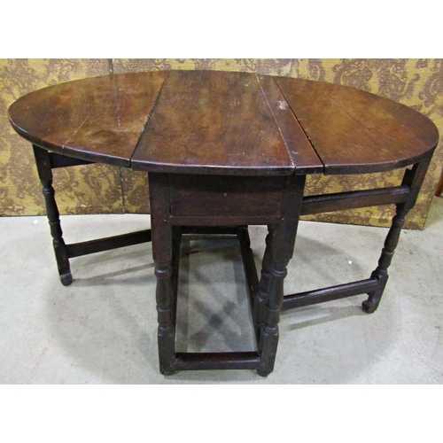 2198 - A Georgian oak oval drop leaf gateleg dining table with three quarter length end frieze drawer raise... 