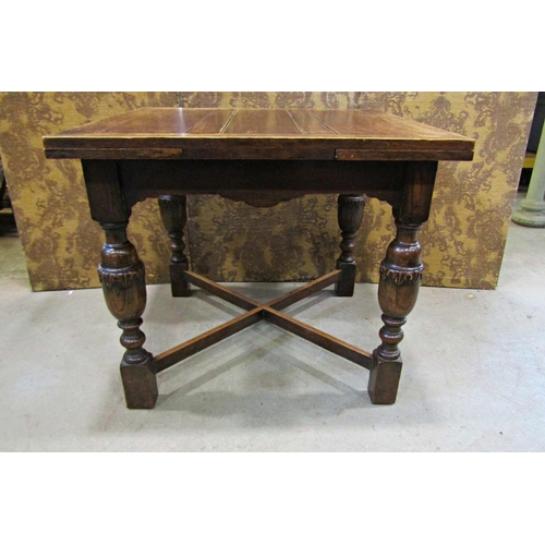 2214 - An oak plank top draw leaf dining table raised on baluster supports united by an X framed stretcher,... 