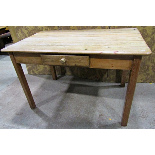 2223 - A stripped pine kitchen table of rectangular form with plank top over a frieze drawer raised on squa... 