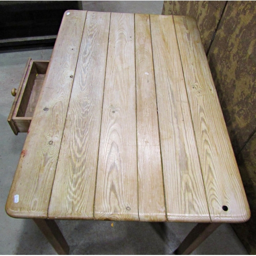 2223 - A stripped pine kitchen table of rectangular form with plank top over a frieze drawer raised on squa... 