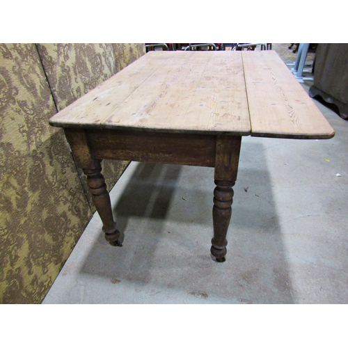 2232 - A Victorian pine drop leaf kitchen table on turned supports, 136cm long x 75cm wide when closed x 12... 