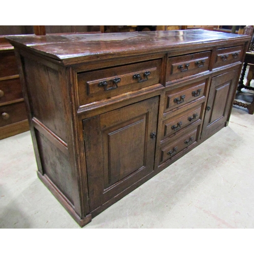 2244 - A Georgian oak dresser base enclosed by a T shaped arrangement of six drawers and two panelled cupbo... 