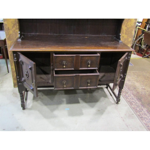 2248 - An Edwardian oak dresser in the Jacobean style, with two central drawers flanked by two cupboards wi... 