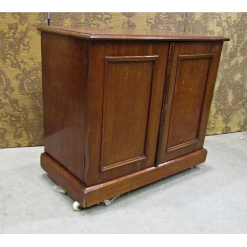 2253 - A Victorian mahogany panelled cupboard of small dimensions enclosed by two panelled doors, 66cm long... 