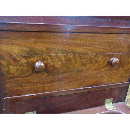 2254 - A Georgian mahogany commode with rising lid, the front elevation presented  as two drawers on bun su... 