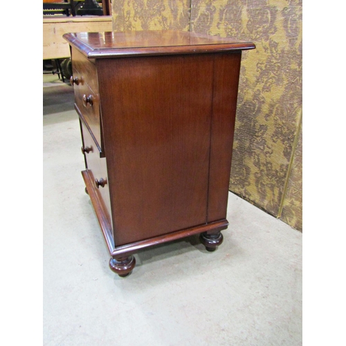 2254 - A Georgian mahogany commode with rising lid, the front elevation presented  as two drawers on bun su... 