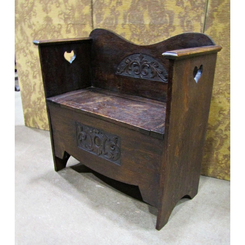 2264 - Late 19th century oak hall settle with box base, shaped outline and carved detail, 76cm wide