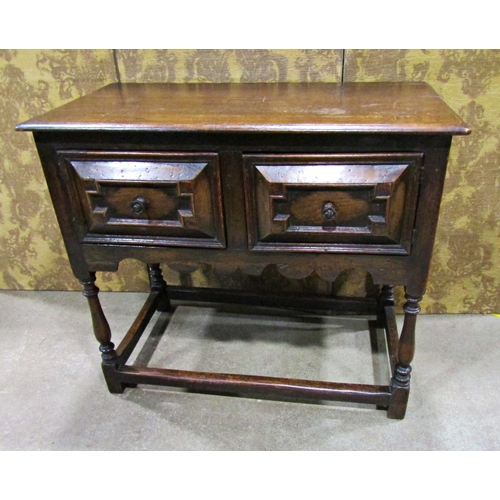 2265 - An old English oak side table in a Jacobean style the front elevation enclosed by two cupboards (dis... 