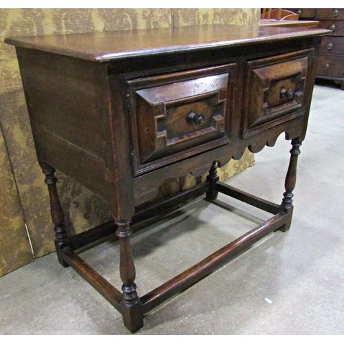 2265 - An old English oak side table in a Jacobean style the front elevation enclosed by two cupboards (dis... 