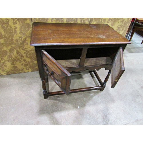 2265 - An old English oak side table in a Jacobean style the front elevation enclosed by two cupboards (dis... 