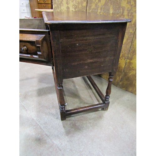 2265 - An old English oak side table in a Jacobean style the front elevation enclosed by two cupboards (dis... 