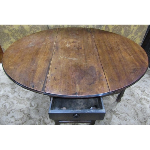 2271 - A Georgian fruitwood gateleg dining table on turned supports enclosing a frieze drawer on shaped fee... 