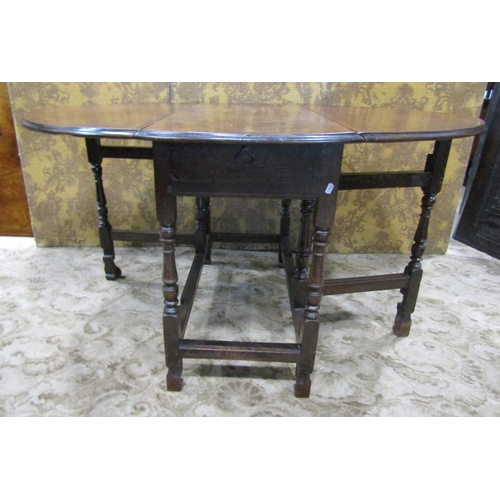 2271 - A Georgian fruitwood gateleg dining table on turned supports enclosing a frieze drawer on shaped fee... 