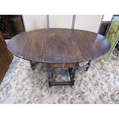 2272 - A Georgian oak gateleg dining table of usual form on turned supports, 105 cm in length