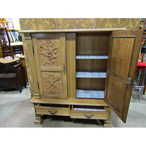 2279 - A pale oak Dutch side cabinet on stand, the cupboard enclosed by a pair of panelled doors with armor... 