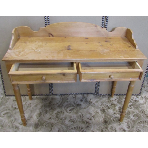 2314 - A waxed pine side table with two frieze drawers, three quarter gallery and raised on turned supports... 