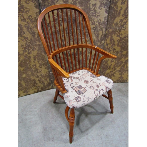 2321 - A Windsor style comb back elbow chair with upholstered seat and crinoline stretcher