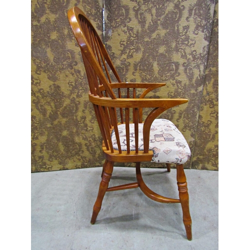 2321 - A Windsor style comb back elbow chair with upholstered seat and crinoline stretcher