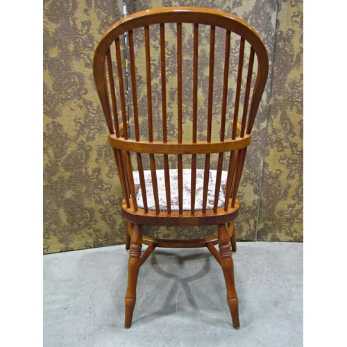 2321 - A Windsor style comb back elbow chair with upholstered seat and crinoline stretcher