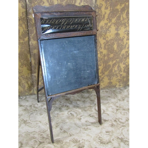 2338 - A late 19th century American child's folding easel enclosing a blackboard, the upper panel showing a... 