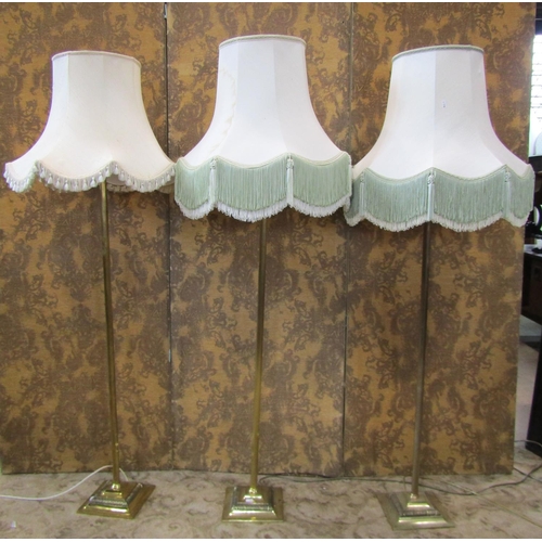 2349 - A set of three brass column lamp standards on square cut bases, together with three industrial green... 