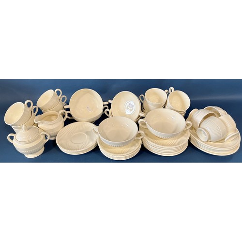 1140 - A collection of Wedgwood cream ground tableware comprising tea cups, saucers, open soup bowls, etc