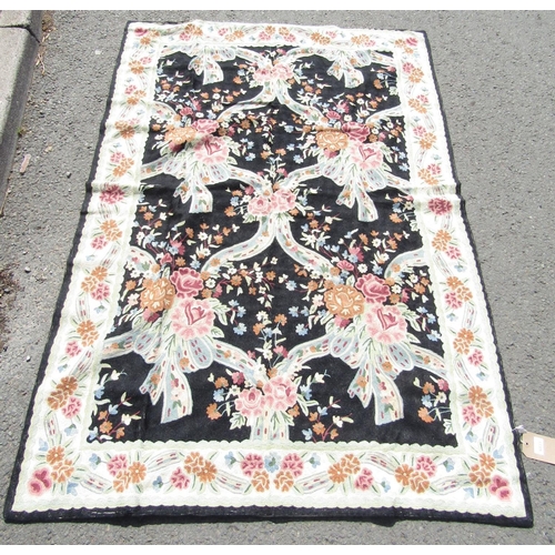 1673 - A Kashmiri hand stitched wool wall hanging, with an overall pattern of pastel coloured flowers on a ... 