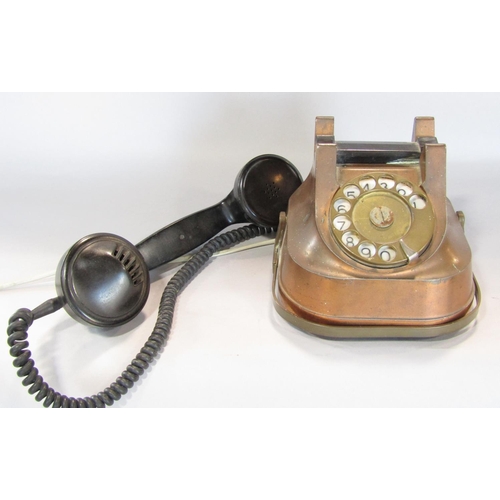 A vintage copper and Bakelite continental rotary telephone converted with  later BT compliant cable.