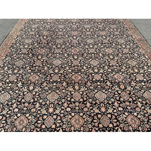 1702 - A large Middle Eastern style carpet with an all over floral pattern on a black field (repaired and s... 