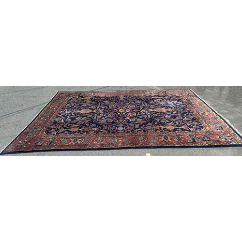 1701 - A large country house Persian design carpet, with vases of flowers and trailing flowers on a blue gr... 