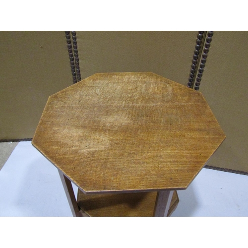 2230A - An arts and crafts style oak two tier occasional table of octagonal form with shaped apron, 53cm acr... 