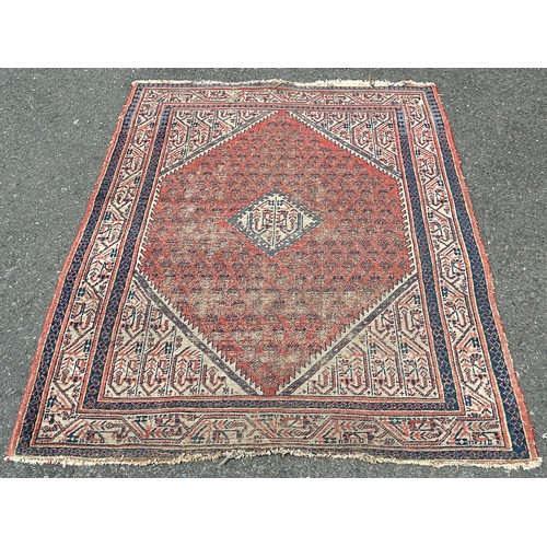 1677 - A Faded and Worn Old Persian Rug with central lozenge shaped panel and boteh design, 153 x 110 cm