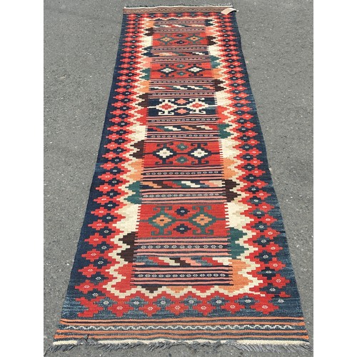 1679 - A Kilim Runner in natural multicoloured tones with a central panel of repeating shapes, hand-woven i... 